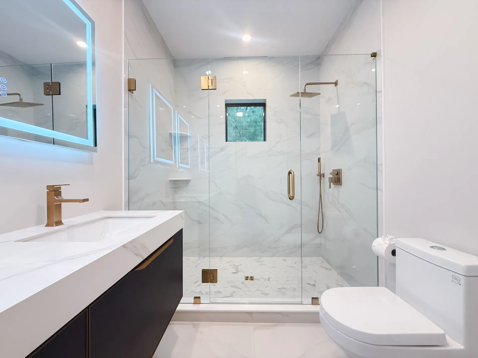 Frameless glass shower door installed in a marble bathroom