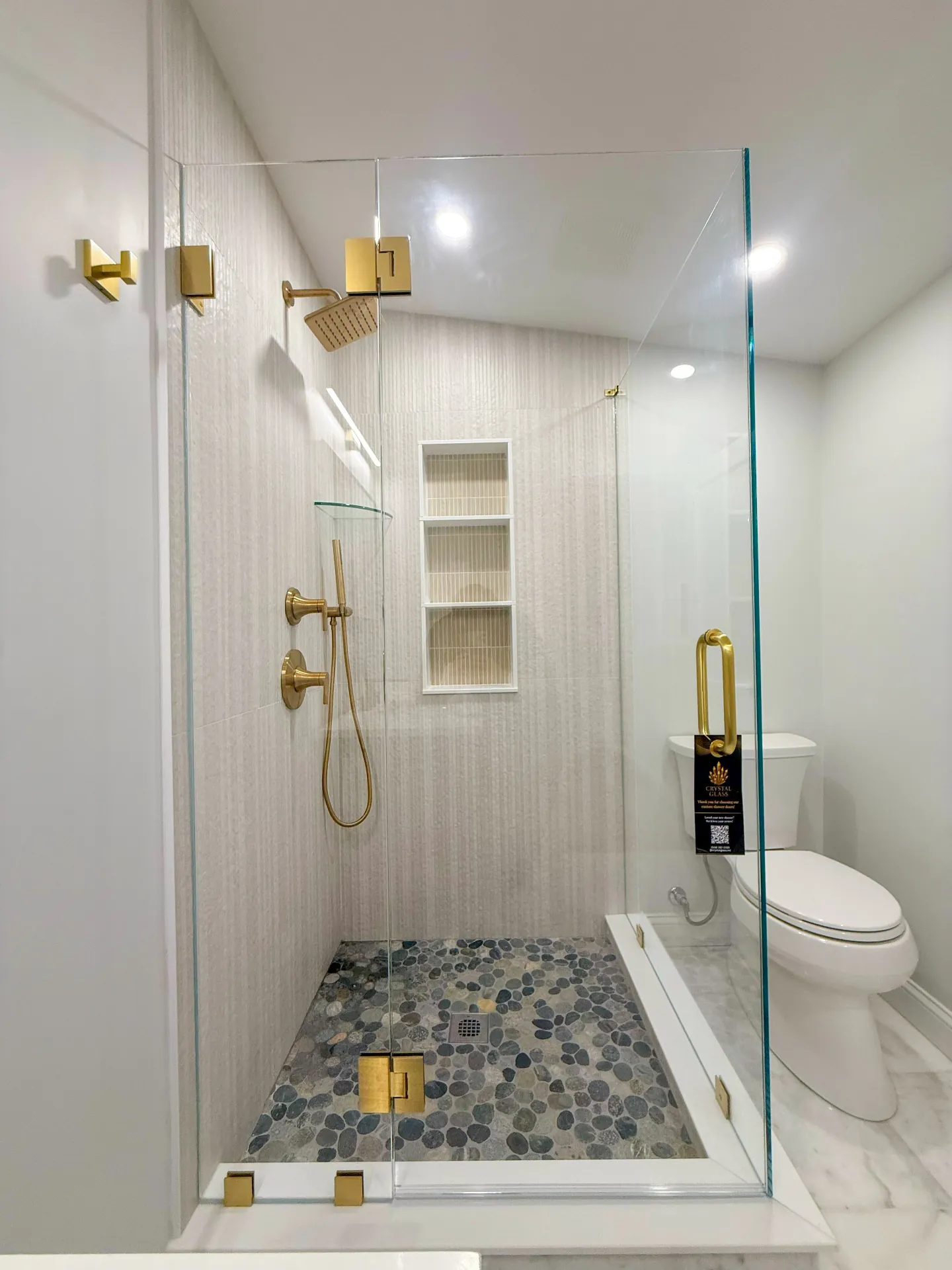 Frameless shower enclosure with gold hardware