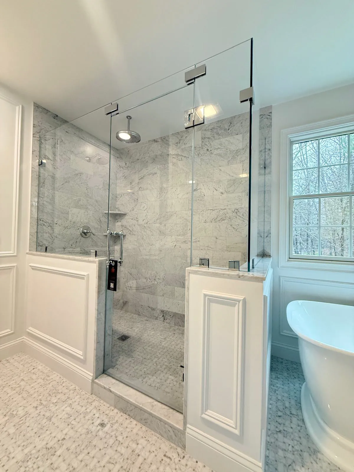 Frameless glass shower next to a freestanding tub