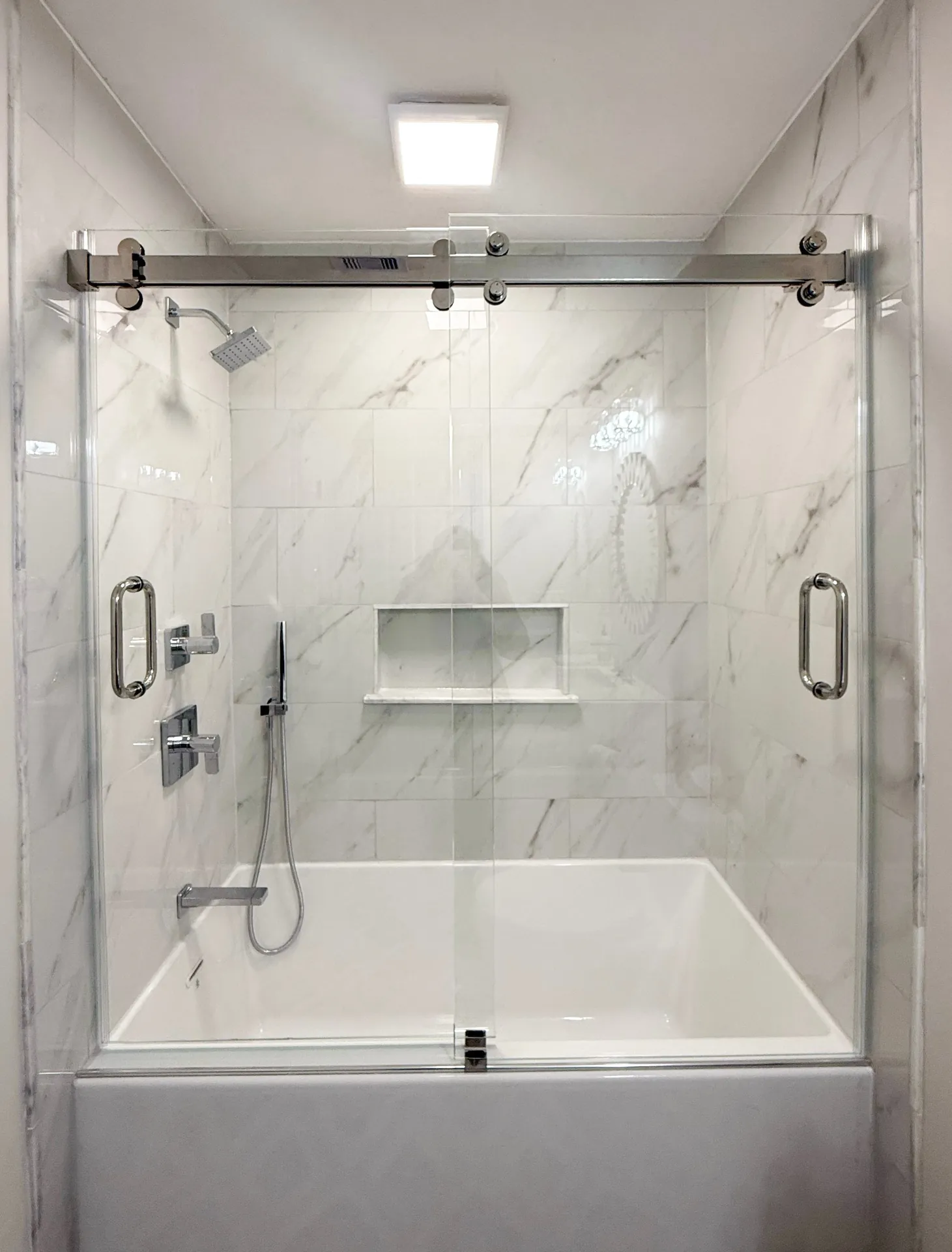 Sliding glass shower door over a bathtub