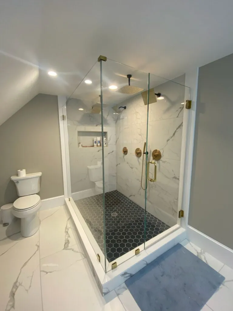 Frameless shower door with black hexagon tile floor