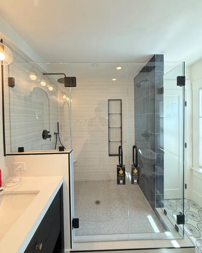 Frameless glass door and return panel in a long bathroom with a double vanity